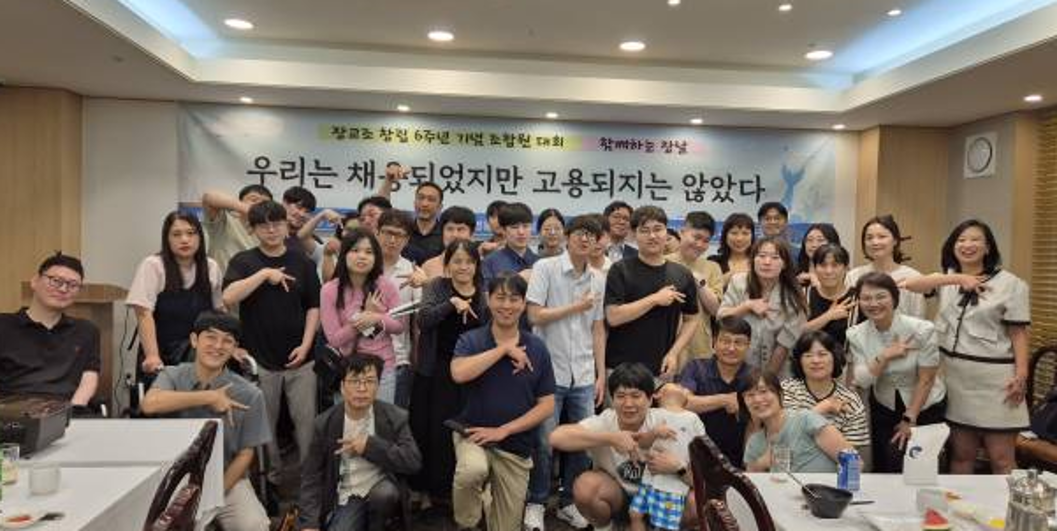 Large group photo showing approximately 50 union members at the 6th anniversary celebration event